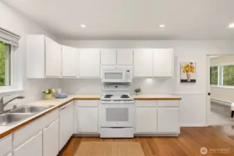 Spacious kitchen with newer hardwood flooring.