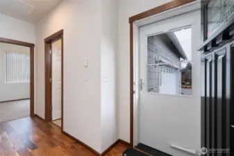 Bright entryway with hardwood floors and security screen door.