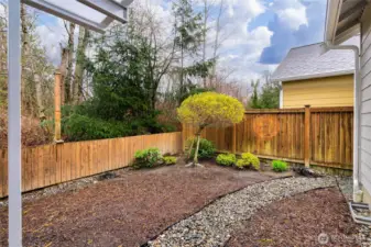 Private fenced backyard with landscaping