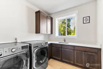 Large laundry room with built-ins for extra storage and a convenient sink.