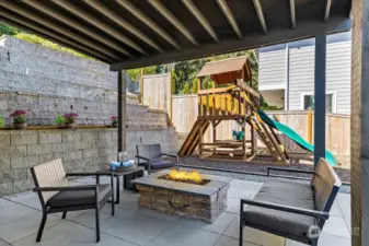 A covered patio with a cozy gas fire pit in the backyard extends your outdoor living.
