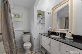 Full Hall Bath with decorative tiled floor, old fashioned tub and modern upgrades.