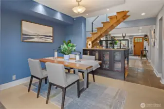 Dining room opens to modern steel cable and wood stairs.