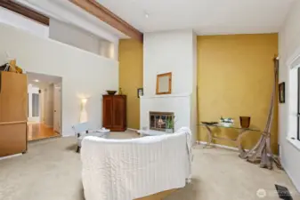 Th living room is anchored by the white brick fireplace.