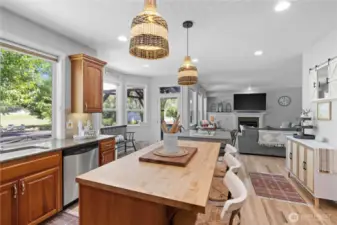Stunning chef's eat in kitchen connects to the adjacent family room, making the space an open and inviting living area. The centerpiece is generous sized island with bar-height seating area, perfect for casual dining and entertaining. The granite countertops are complemented with rich cherrywood cabinets that add warmth. The kitchen features a walk in pantry for ample storage and stainless steel appliances that cater to all culinary needs. Large windows flood the space with warm and natural light, enhancing the welcoming atmosphere and making it the heart of the home!