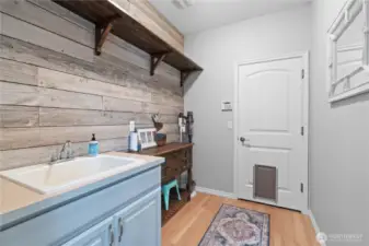 There are two conveniently located laundry areas- one on the main level and another upstairs, proving ultimate ease and flexibility. The main floor space showcases beautiful wood floors, sink, counter and cabinetry for ample storage and work space. The shiplap wall adds a charming country touch