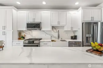Gorgeous slab quartz countertops and backsplash highlight the newer stainless steel GE Profile appliances - double oven with griddle and air fryer feature, refrigerator with ice & water in the door, microwave/hood with steam feature and dishwasher. The farmhouse sink comes with all the accessories so even washing dishes is fun!