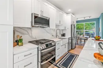 Gorgeous slab quartz countertops and backsplash highlight the newer stainless steel GE Profile appliances - double oven with griddle and air fryer feature, refrigerator with ice & water in the door, microwave/hood with steam feature and dishwasher. The farmhouse sink comes with all the accessories so even washing dishes is fun!