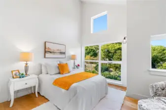 Vaulted ceilings and oversized windows (including one high up with sweeping views) flood this bedroom with   light—hello, perfect spot for a lofted bed! A cozy nook with its own window is just right for a desk or reading chair.