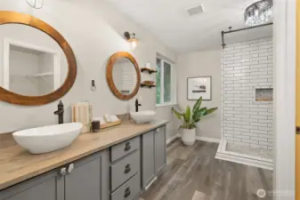 The updated primary bathroom offers double vessel sinks and a large custom tiled shower.