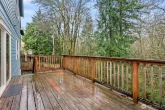 The deck is located on the back of the house and it overlooks the forested greenbelt that is great for privacy.