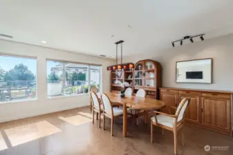 The spacious dining room enjoys stellar views and an art glass chandelier.