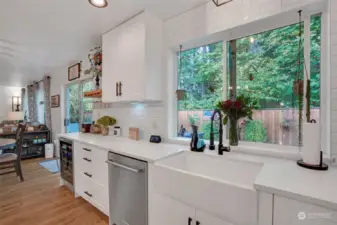 A farm sink, sparkling countertops, and full height backsplash complement this kitchen.