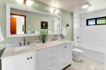 Primary bath was completely remodeled with marble countertops, marble hex floor tiles and stacked subway around the tub with a niche.