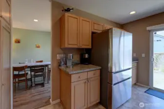 Newer fridge flanked by cabinets and countertops.