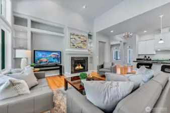 The gas fireplace is the focal point of the great room and there is a large TV niche and glass display shelves with lighting.