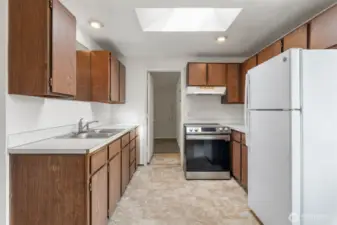 Galley style kitchen leads to bonus room.