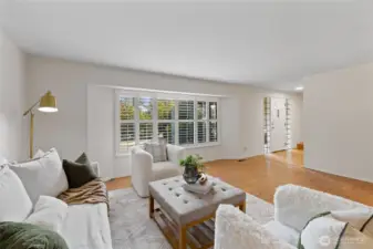 The living room features plantation shutters.