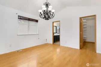 Primary bedroom with vaulted ceilings, en suite bath, and walk-in closet.