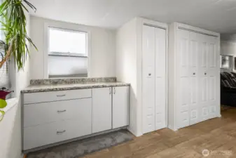 A view of the additional kitchen storage and counter space, a small pantry, and a laundry area.