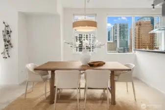 Dine beneath stylish pendant lighting with sparkling city lights in the background.