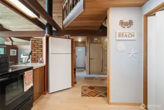 Kitchen to entry door/hallway.  Washer/dryer on left.