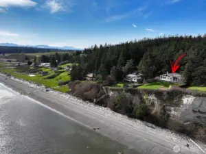 View of home set well back on medium bank and community beach home.
