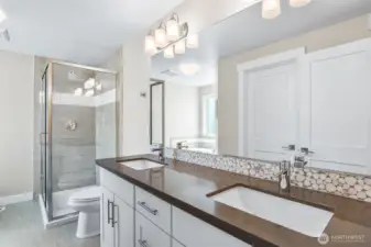 Primary bath with newer white cabinets, Quartz surface and tiled shower.