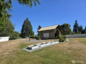 Mature blueberry bushes and raised garden beds off the barn, firepit and movie space