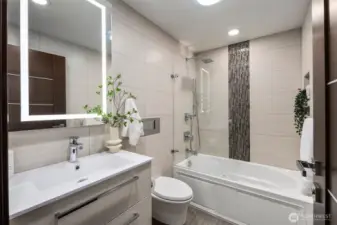 Serene guest bath with deep jetted soaking tub and sleek tilework