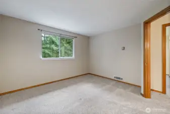 The first bedroom is spacious with a view of the backyard.