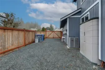 This is the RV parking space with 50 amp electrical hookup.  The heat pump is on the right perfect for AC in the summer.  The storage unit on the right also stays with this home.