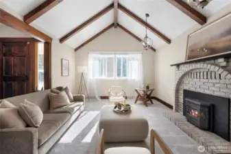 Vaulted ceilings, wood beams, and bright windows make the home feel open yet cozy.