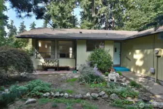 One of the best features of this home is the level lot w/mature landscaping and the privacy it provides. A sweet covered patio, too! The 2 large windows are to the open living/dining room. Smaller window is your kitchen sink window! This is the east side of the home.