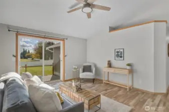 Looking through the living room to the sliding glass doors out to the patio and large fenced backyard.
