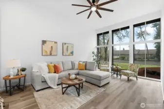 The front room has soaring ceilings and floor to ceiling windows