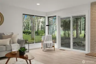 Living room with floor to ceiling windows and sliding doors to the patio