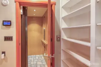 The elevator is a luxurious addition to this home. It is flanked by built-in bookcases lining the wall.