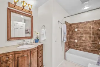Beautifully updated main hall bathroom with tile wrapped shower over tub.