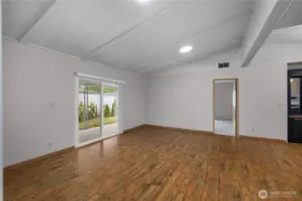 Slider to covered awning directly off living room, primary bedroom is straight ahead. Note the newly installed skylight suntunnels which brighten up the space!