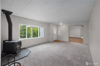 View from 2nd living space to entryway and into primary living room directly ahead. Note the brand new carpeting!