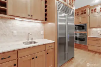 High-end Sub-Zero fridge paired with a convenient secondary sink—perfect for prepping and entertaining with ease.