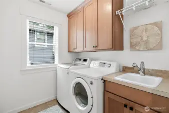 Equipped with a handy sink and ample cabinetry, making laundry tasks organized and efficient.
