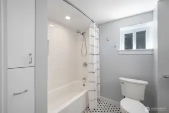 Fully tiled surround and newer bathtub. The closets in the photo, pull all the way out for deep storage. There are also large linen closets on both floors.