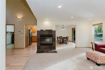 A double sided wood-burning fireplace is open to the family room, kitchen, and dining area.