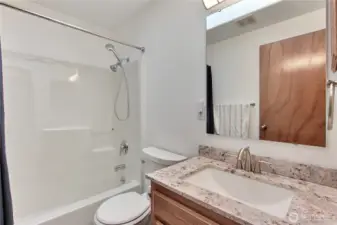 Full kids/guest bath. Nicely updated solid-surface countertop.