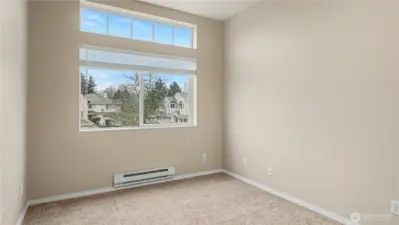 Another view of the inviting guest bedroom, highlighting its spacious layout and ample natural light.