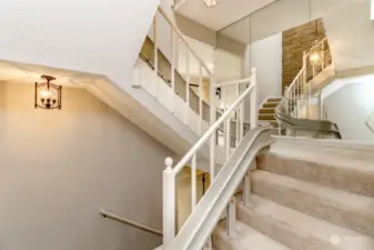 There is a main, upper and lower level with 3 story ceilings and a skylight above. A stair chair cozies up to a railing leaving plenty of space to walk the wide stairs.