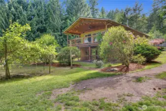 A true garden-to-table lifestyle—raised beds, lush landscaping, and a sprawling lawn that wraps around the home’s covered outdoor spaces.