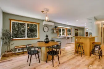 Light-filled dining nook and breakfast bar offer casual gathering space with views of the trees—perfect for everyday meals or weekend brunch.
